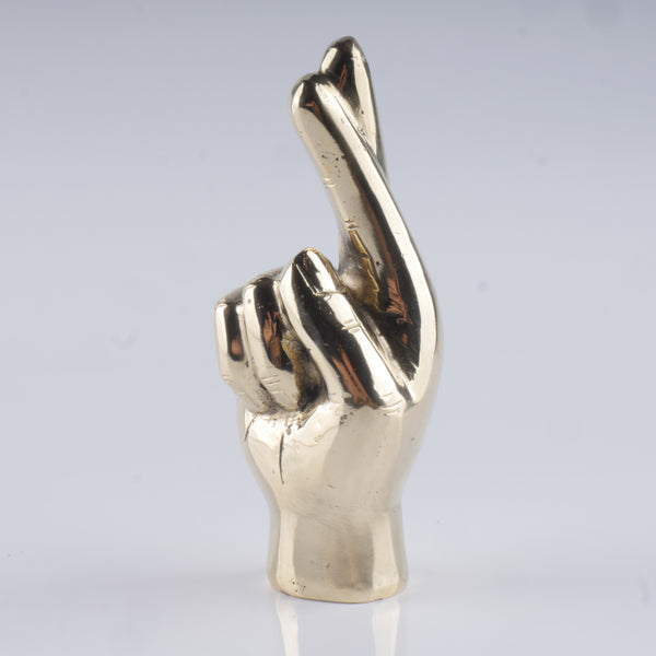 a metal sculpture of a hand making a peace sign