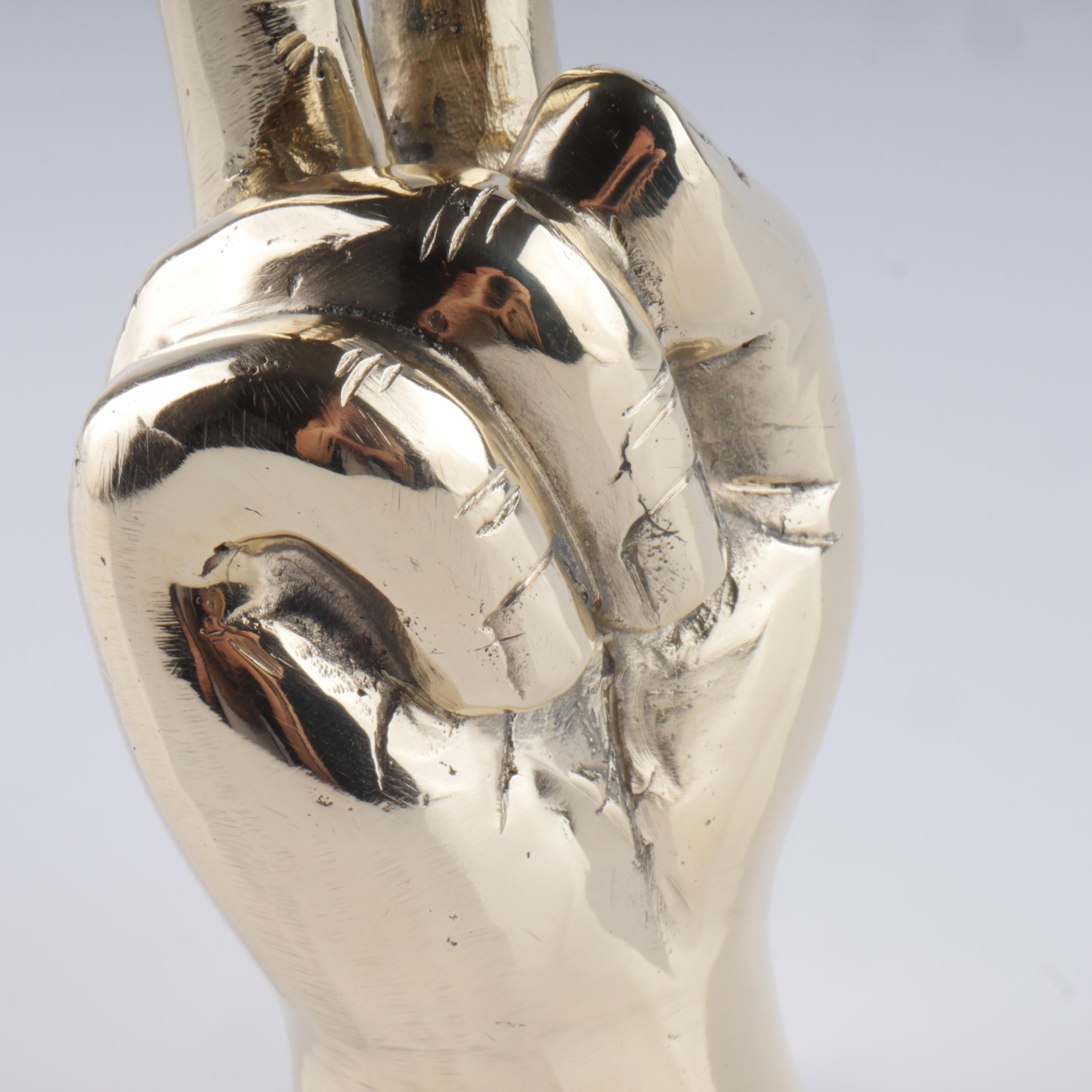 a silver sculpture of a hand holding a ball