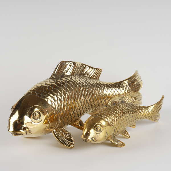 a pair of gold fish figurines sitting on top of a table