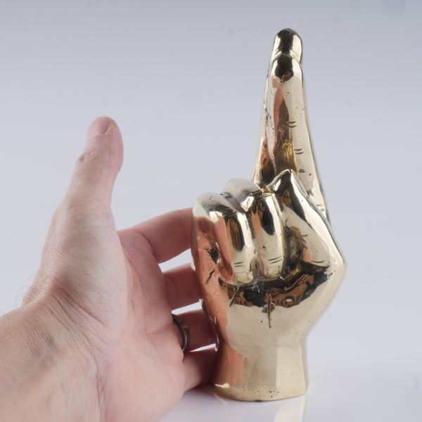 a hand that is holding a gold object