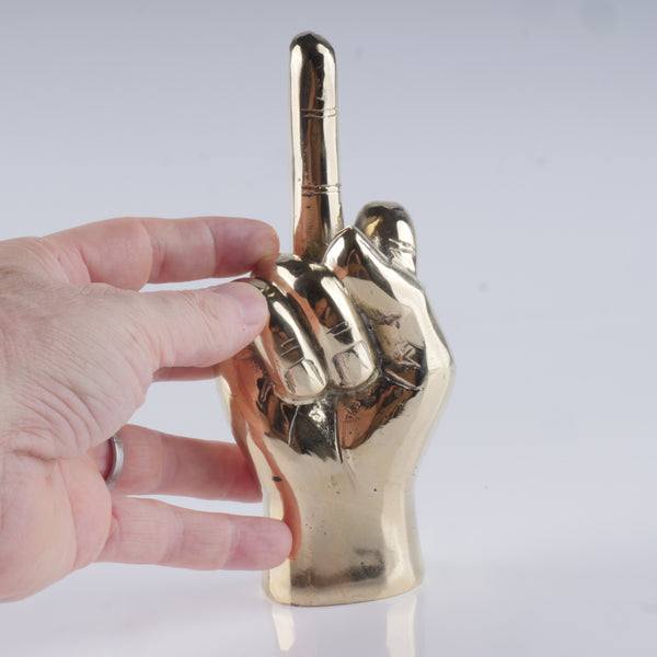 a hand holding a golden metal object in it's right hand
