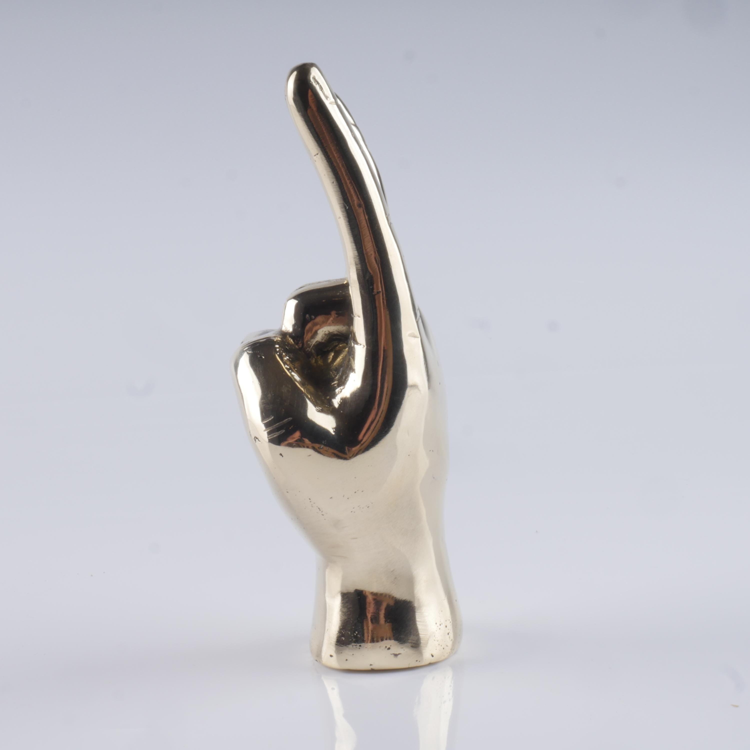 a silver statue of a person making a hand sign