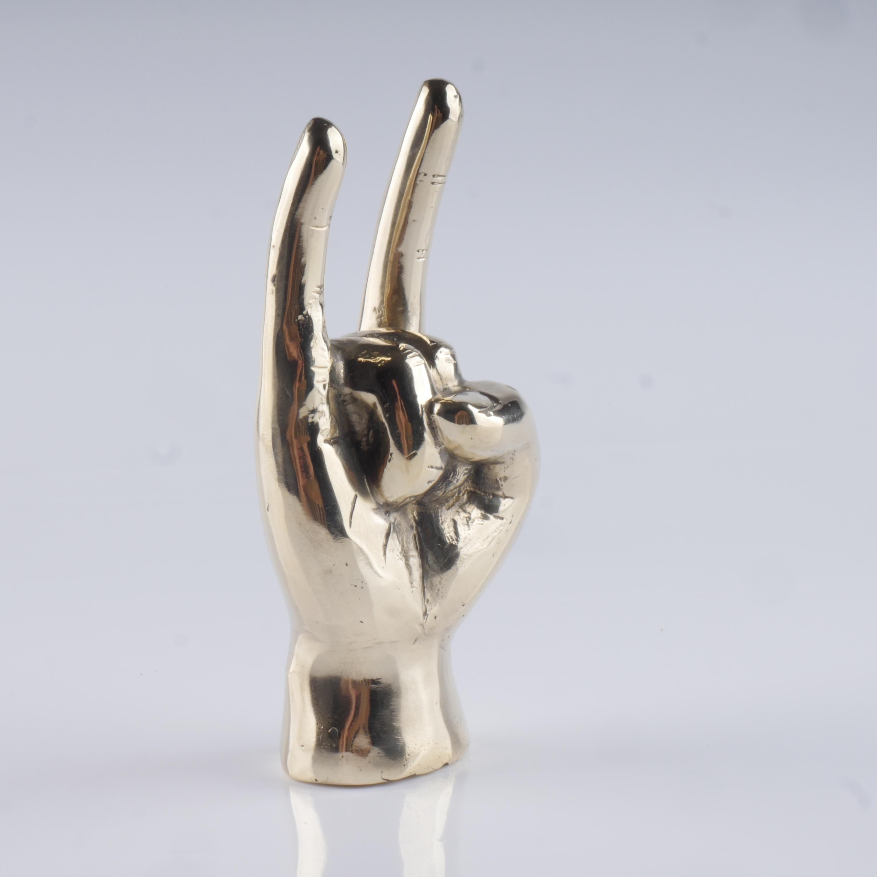 a silver statue of a hand making a peace sign