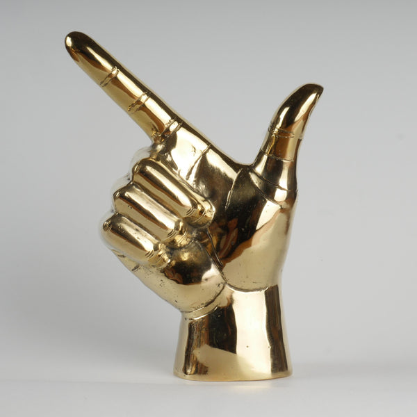 a gold colored statue of a hand making a peace sign
