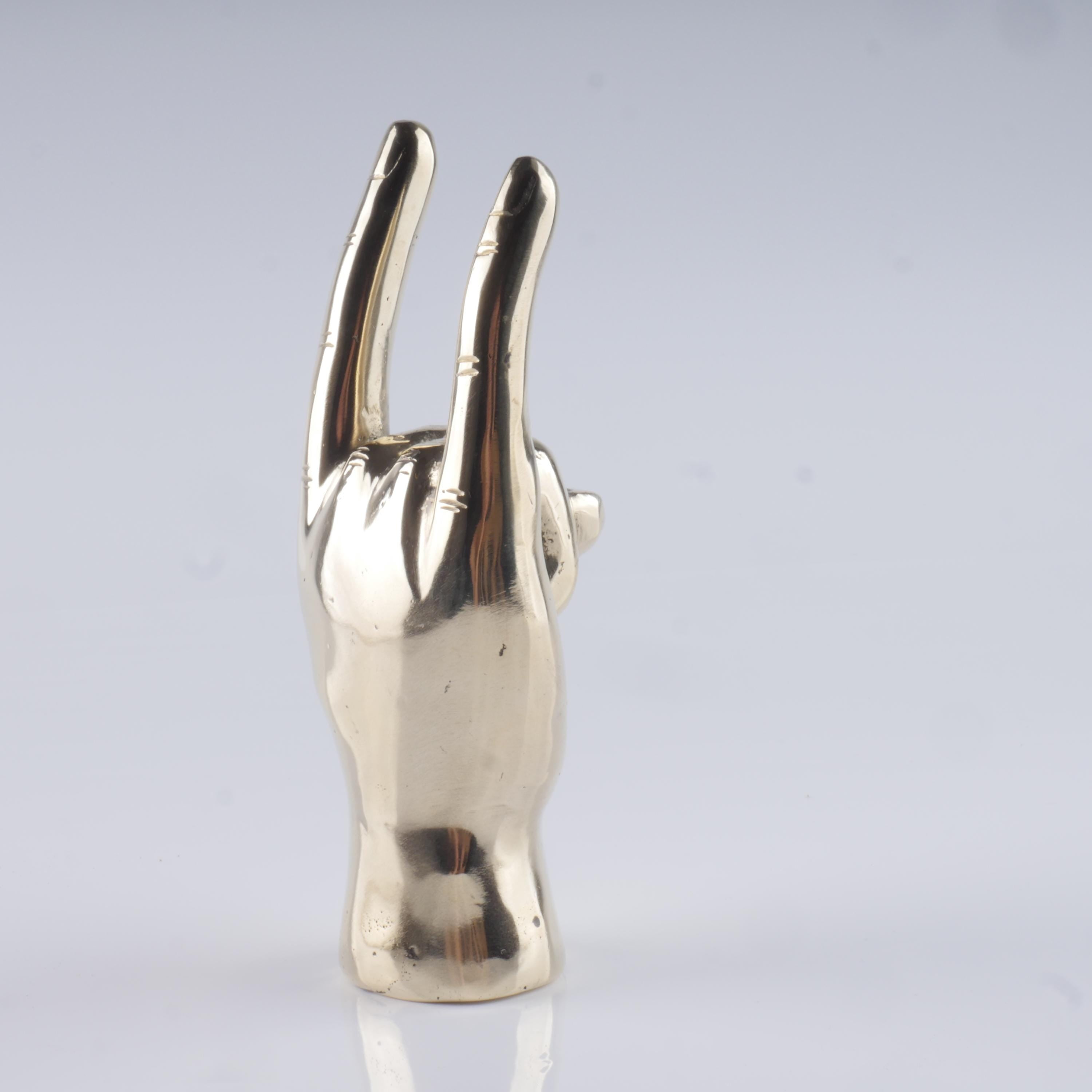 a silver statue of a hand making a peace sign
