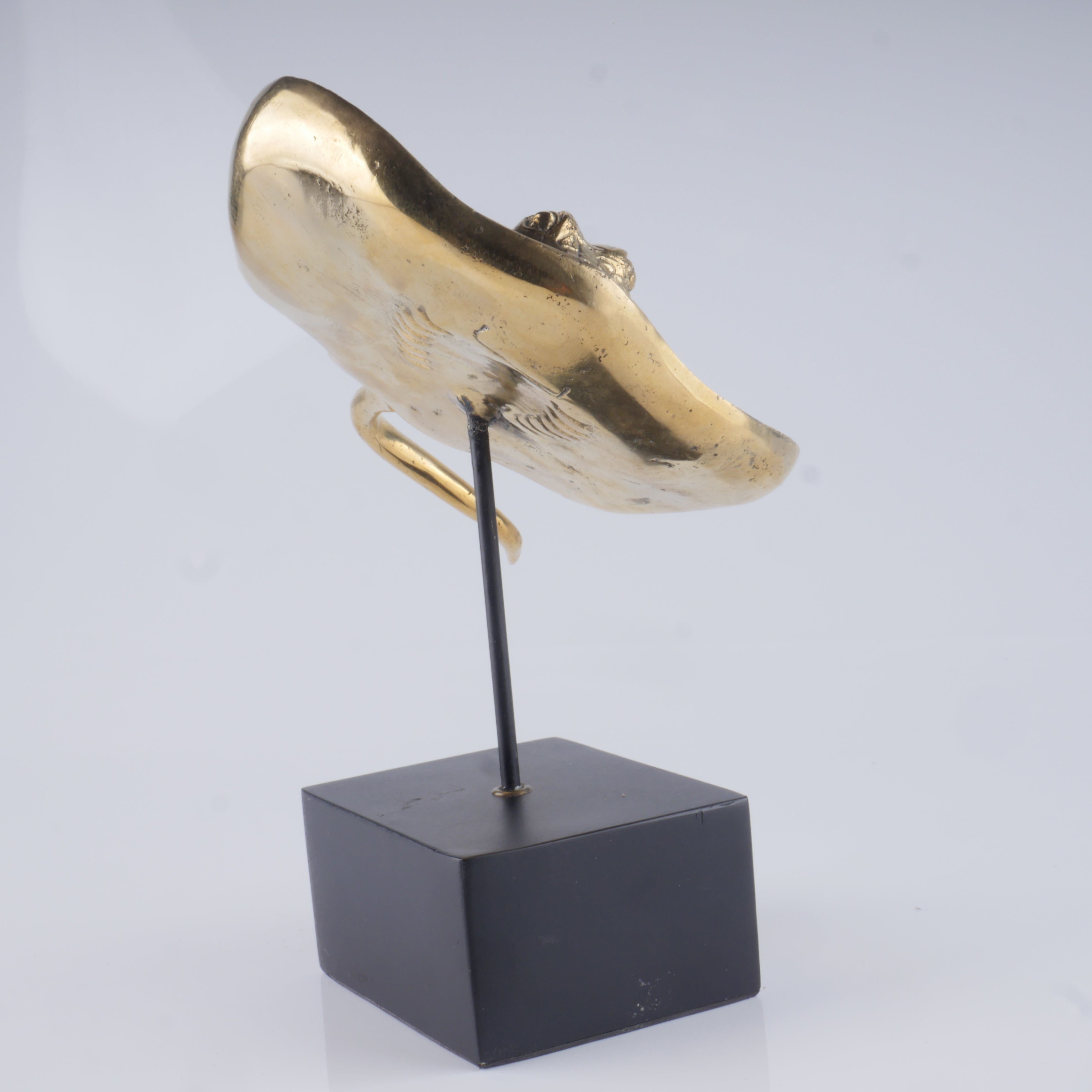 a gold sculpture of a dog's head on a black stand