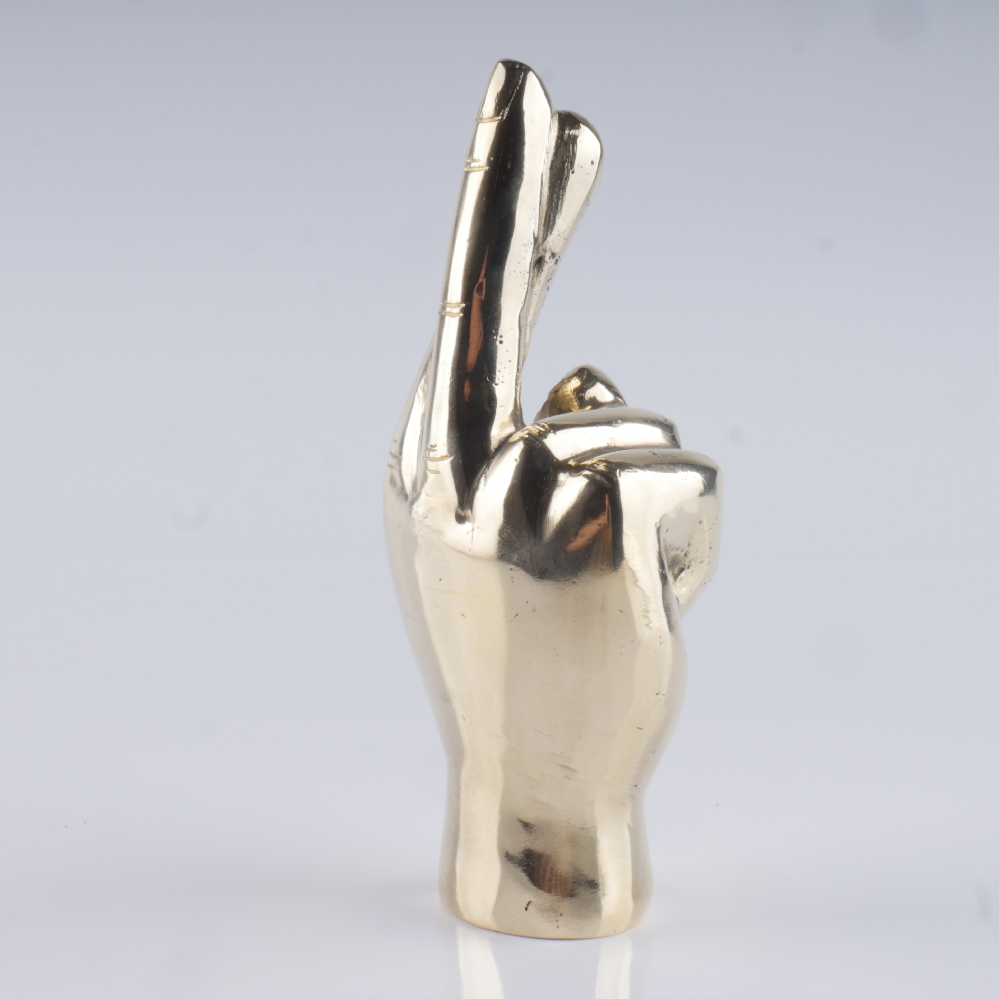 a silver statue of a hand making a peace sign