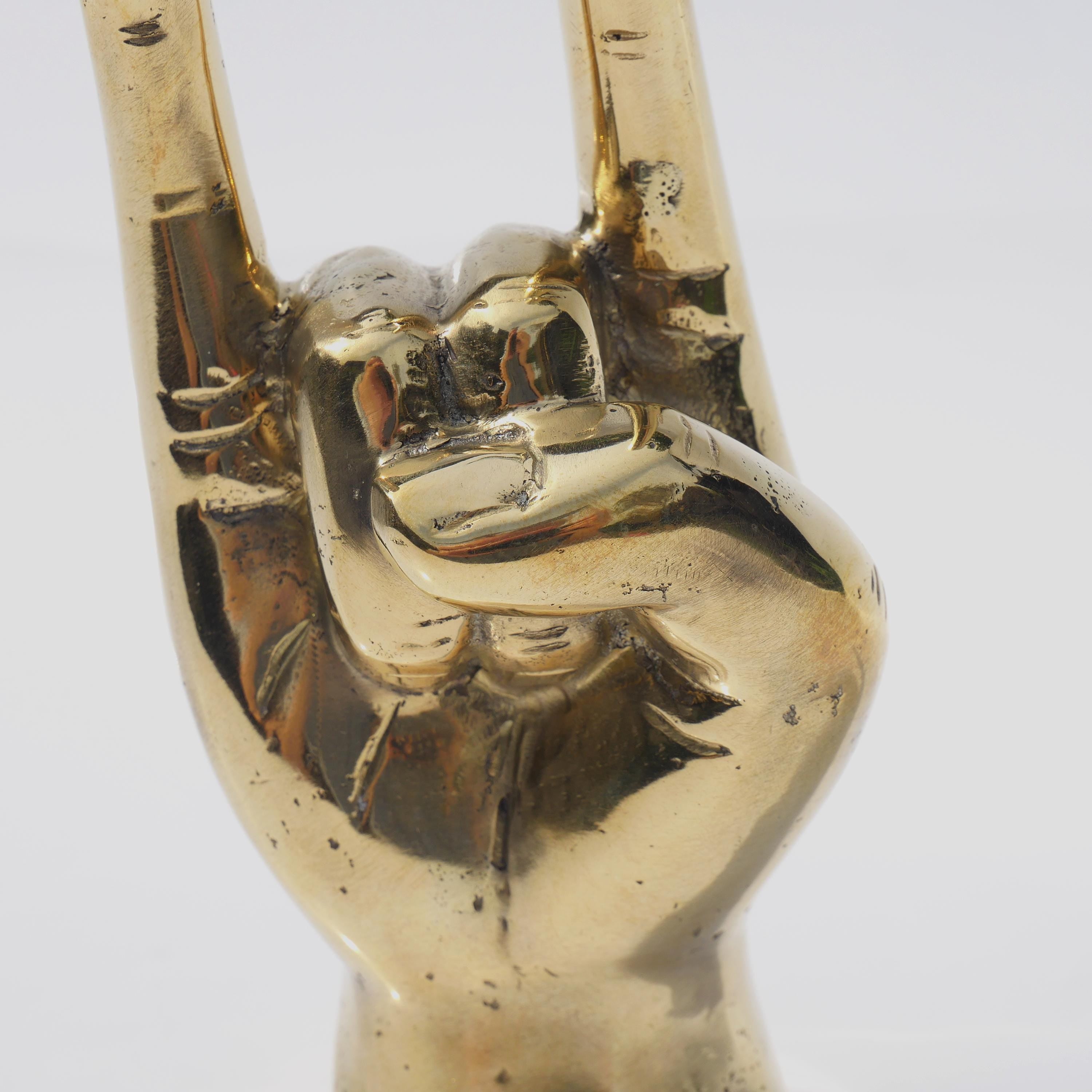 a gold statue of a hand holding a peace sign