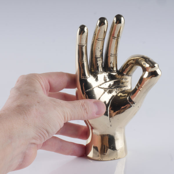 a hand that is holding a gold object