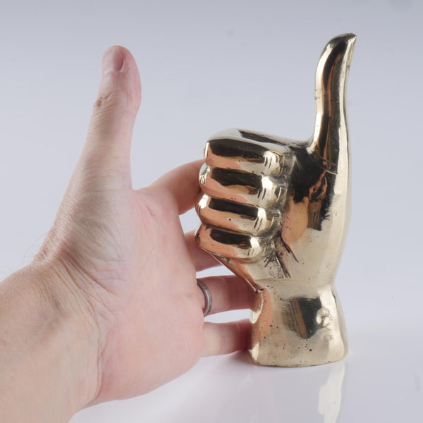 a hand that is holding a gold metal object